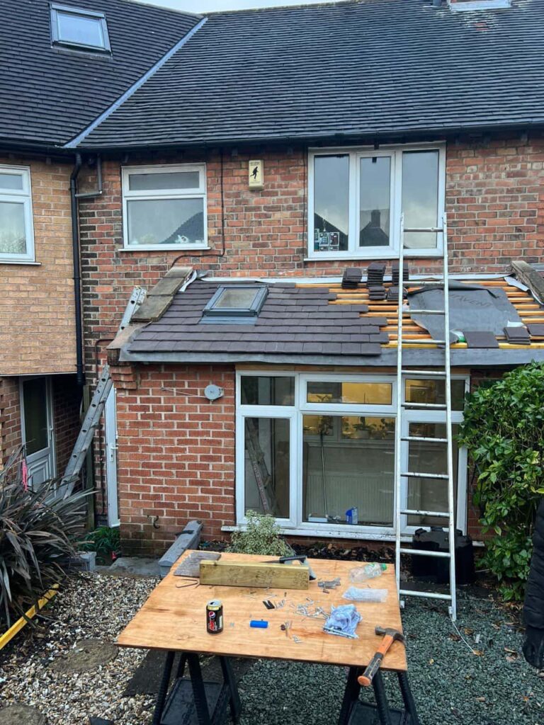 This is a photo of a roof extension that is having new roof tiles installed. This is a photo taken from the roof ridge looking down a tiled pitched roof on to a flat roof. Works carried out by Nettleham Roofing Repairs