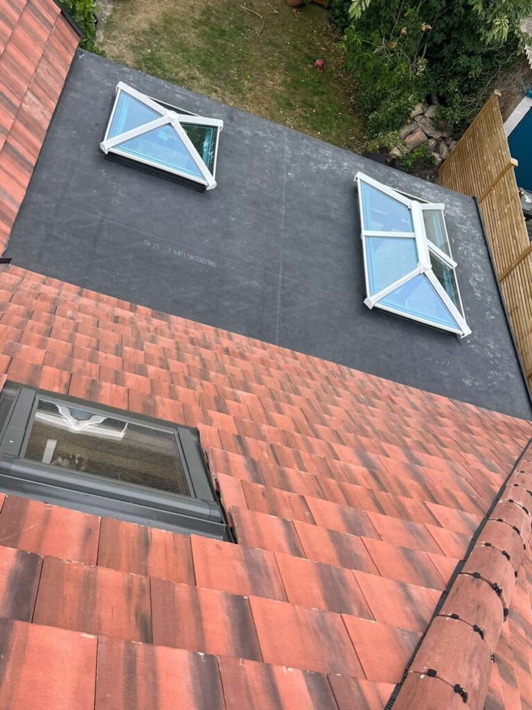 This is a photo taken from the roof ridge looking down a tiled pitched roof on to a flat roof. Works carried out by Nettleham Roofing Repairs